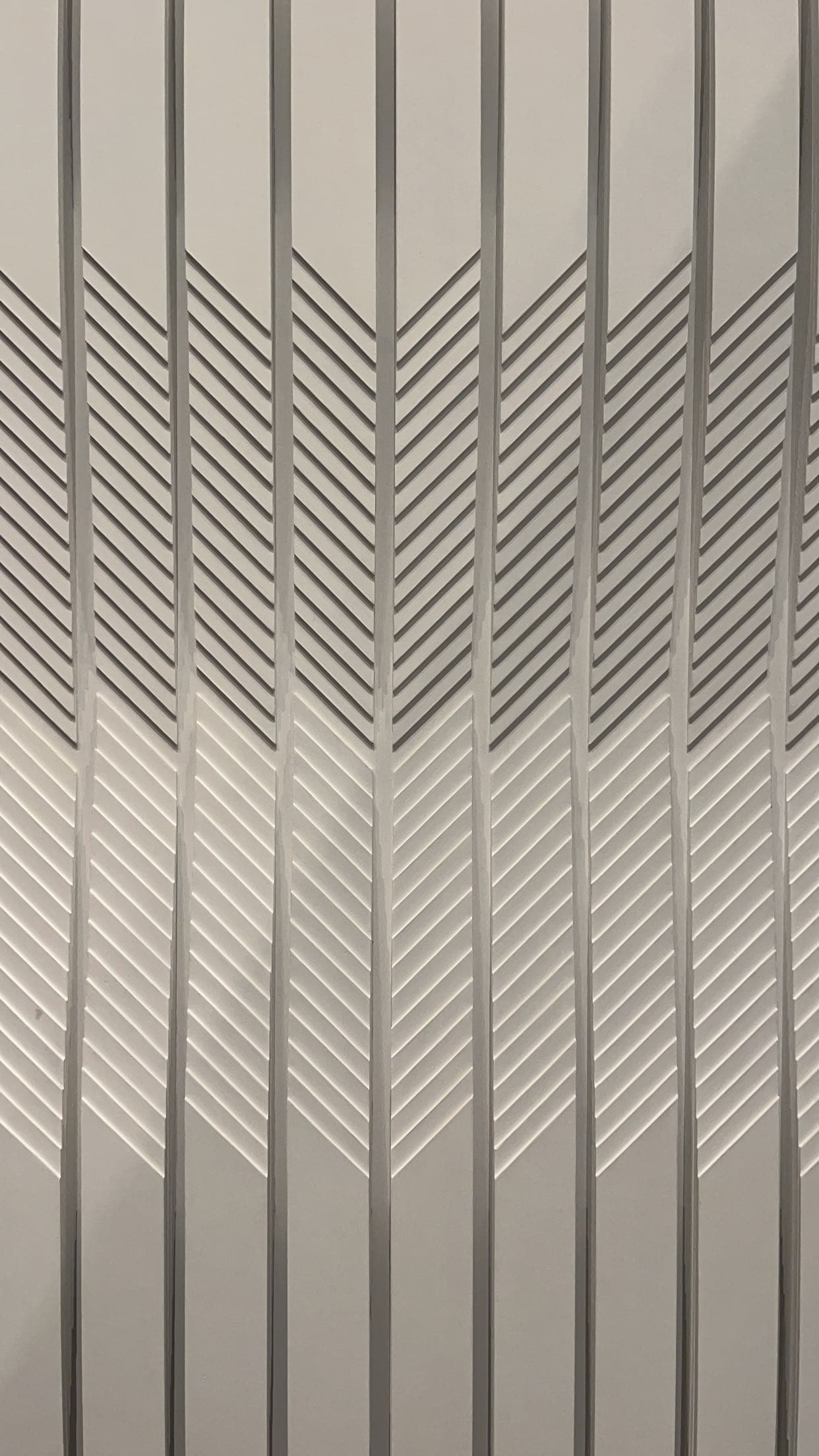 Modern light gray wall panel with a 3D geometric chevron and vertical line pattern.